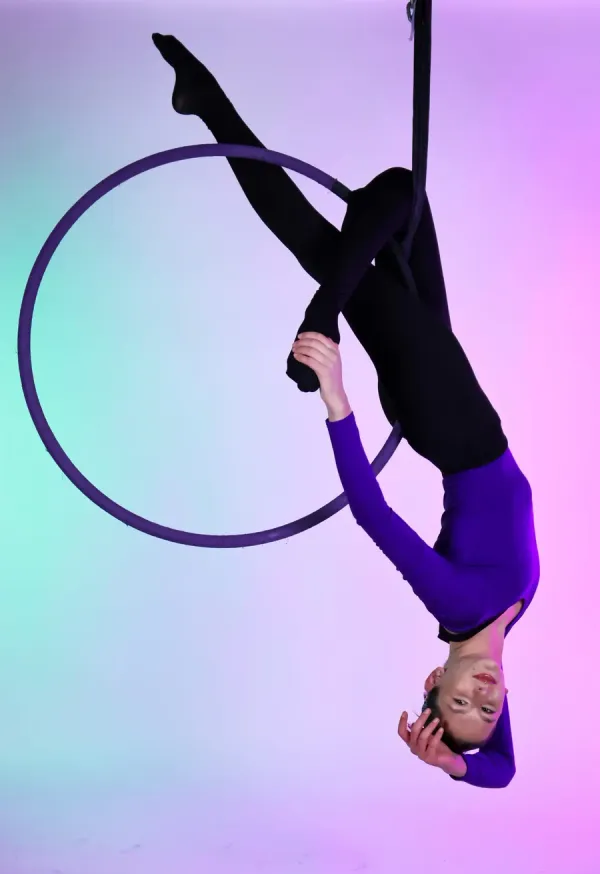 Lyra hoop class — spins, poses and transitions on a suspended steel hoop. Lyra student posing inside a suspended steel aerial hoop in a Flexibility in Flight class in Chester, NY